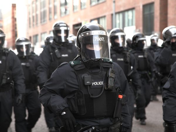 Riot police march in unison, following the trail of loyalists flooding back into East Belfast, 2013. Photo: Joshua Hayes on Flickr.