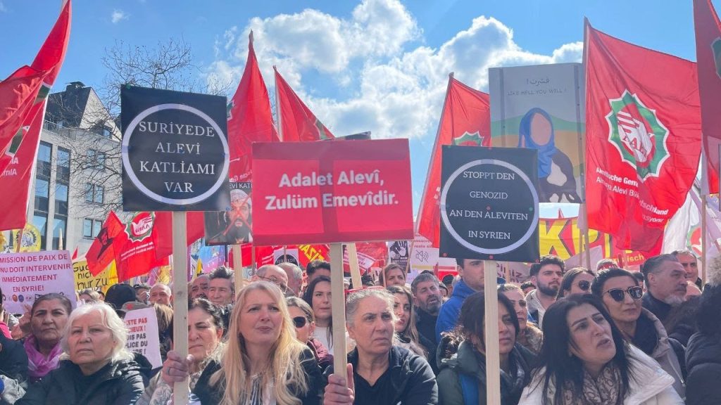 Protest in Köln, Germany, against the Alawite massacres in Syria, 15 March 2025. Photo: Pir Haber Ajansı on Wikimedia Commons.