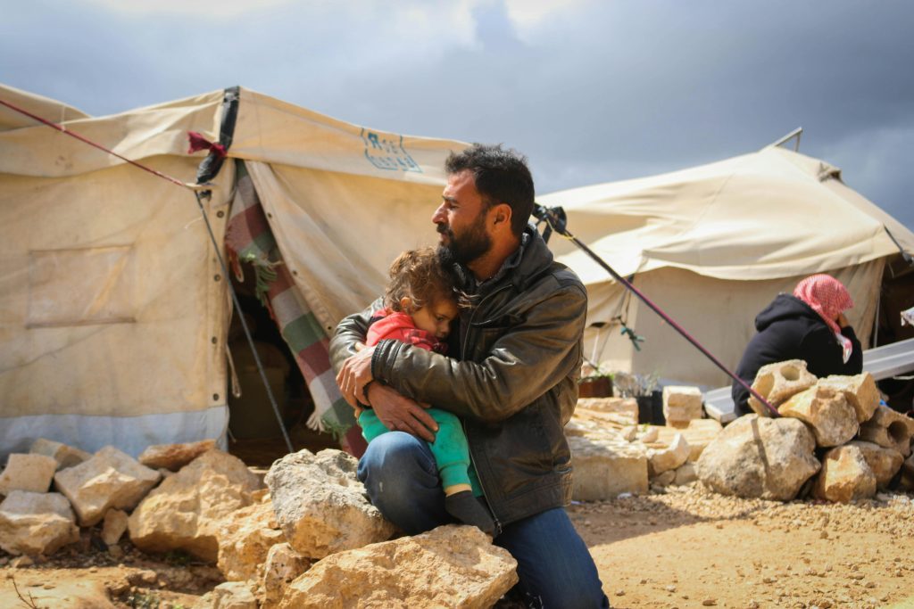 Man Holding His Daughter on a Campsite. Photo: Ahmed Akacha on Pexels.
