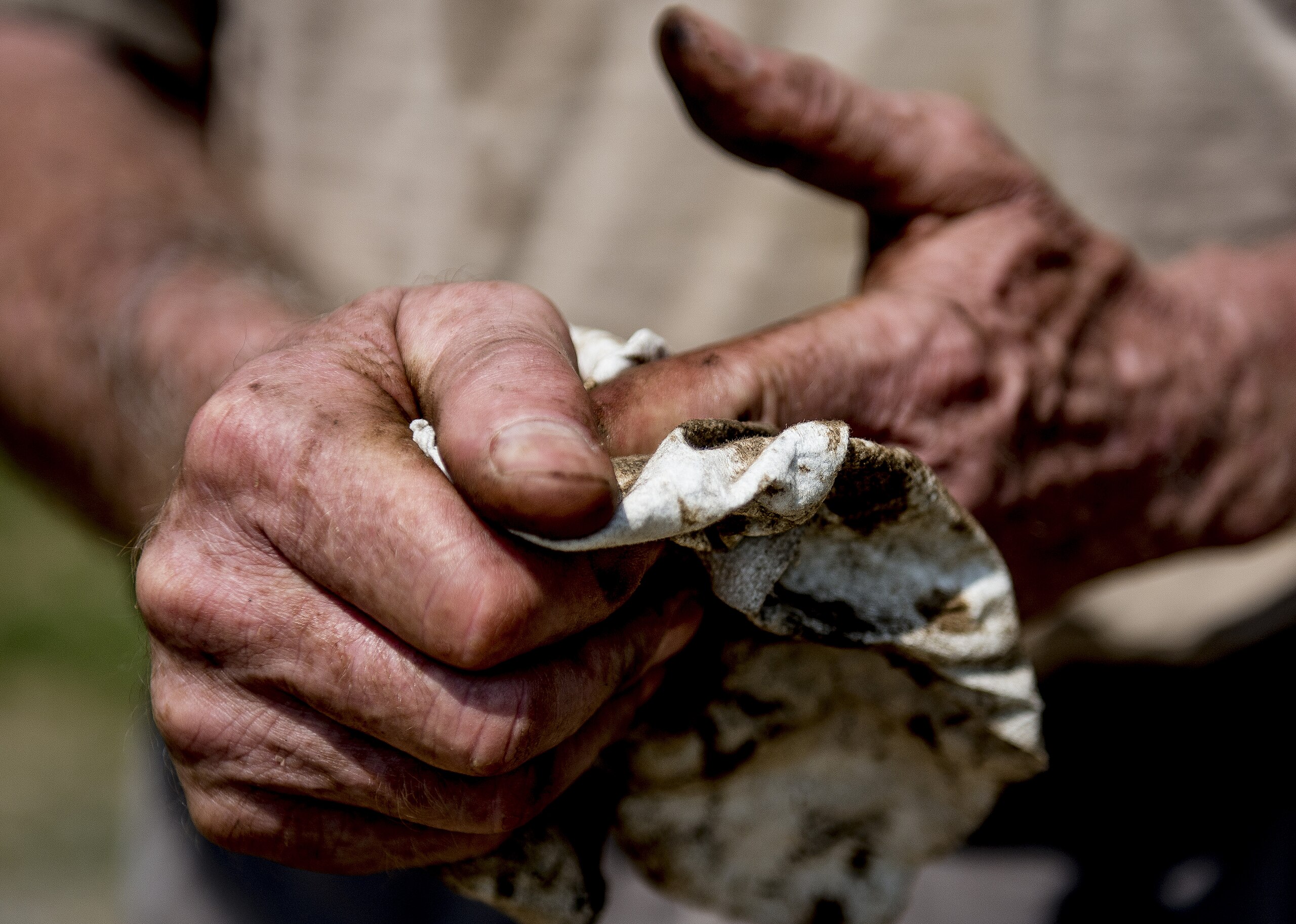 Guy Moore wipes his hands off after a day of working in the filed and fixing equipment that broke while he was working June 18, 2014, at Larriland Farm, Md. The farm is run primarily by family members and some migrant workers. Photo: SrA Dennis Sloan, U.S. Department of Defense Current Photos on Wikimedia Commons.