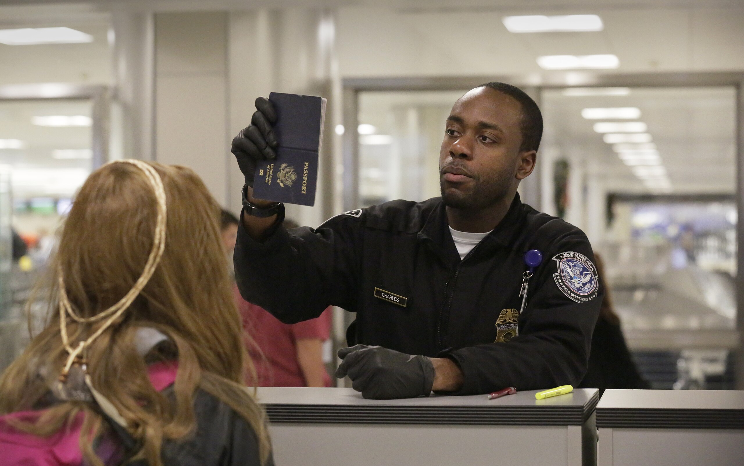 U.S. Customs and Border Protection officers screen international passengers arriving at the Dulles International Airport in Dulles, Va., November 29, 2016. U.S. Customs and Border Protection Photo by Glenn Fawcett on Flickr. United States Government Work.