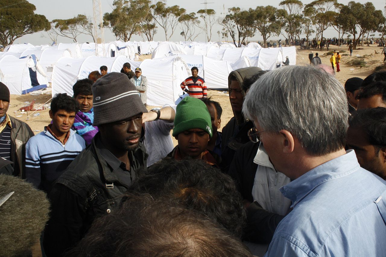 UK International Development Secretary, Andrew Mitchell, talks to migrants at a transit camp near the Tunisian border with Libya. More than 100,000 people have crossed the border from Libya in the past week. (Photo: DFID / Flickr.com)