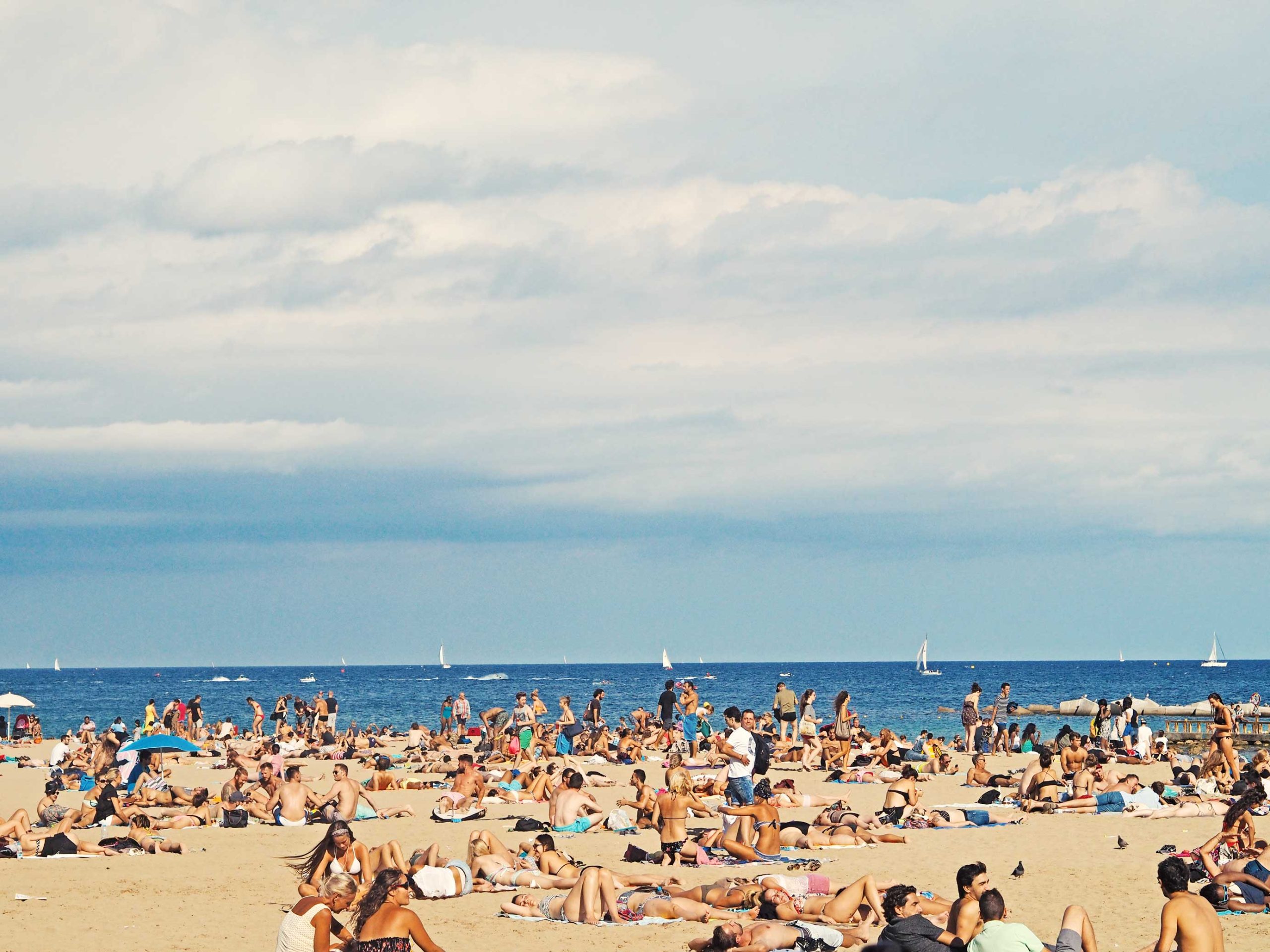 Crowded Barcelona beach. Photo source: Unsplash / Wikimedia Commons.