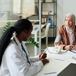 A woman in a hijab receives advice from a doctor. Source: Shutterstock.