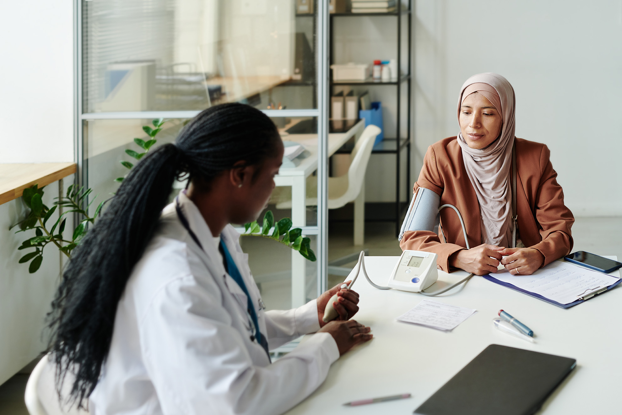 A woman in a hijab receives advice from a doctor. Source: Shutterstock.